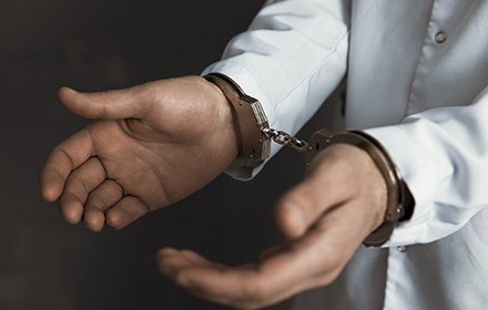 Close-up of Handcuffed Healthcare Professional After Paying Patients with Gift Cards