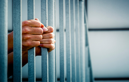 Close-Up of Hands Grabbing the Bars of a Jail Cell After an Arrest in Miami