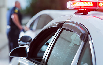 Side of Police Car Behind a Law Enforcement Officer During a Traffic Stop