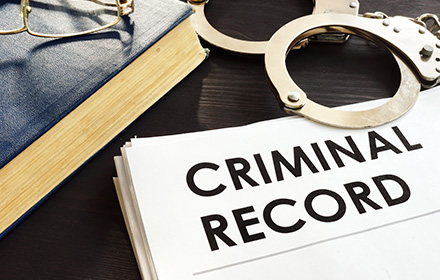 Criminal Record Next to Handcuffs To Represent the Weight of Sealing and Expungement