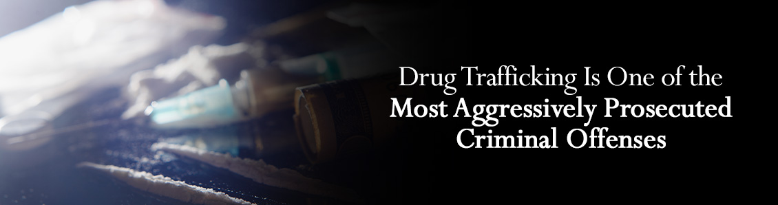 Syringes and Packets of Drug on a Black Surface To Represent Drug Trafficking Charges