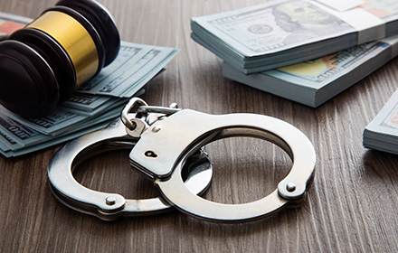 Wad of Money Next to Handcuffs and Gavel To Represent the Prosecution of Fraud-Related Offenses