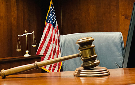 Judge Gavel, Scales of Justice and U.S. Flag on Top of a Desk at Court