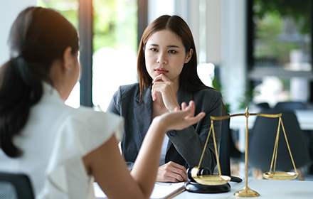 Attorney and Defendant Sitting on Desk and Discussing Eligibility to Florida Pre-Trial Programs